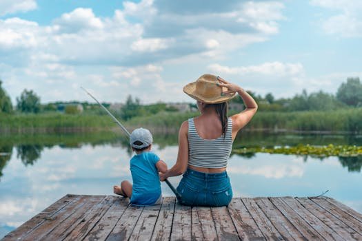 A mom and her child fishing on a peaceful wooden dock by a calm lake in Ukraine.