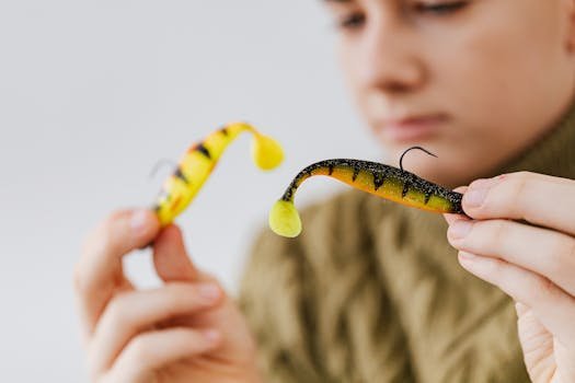 Person examining colorful fishing lures, focusing on detail and design.